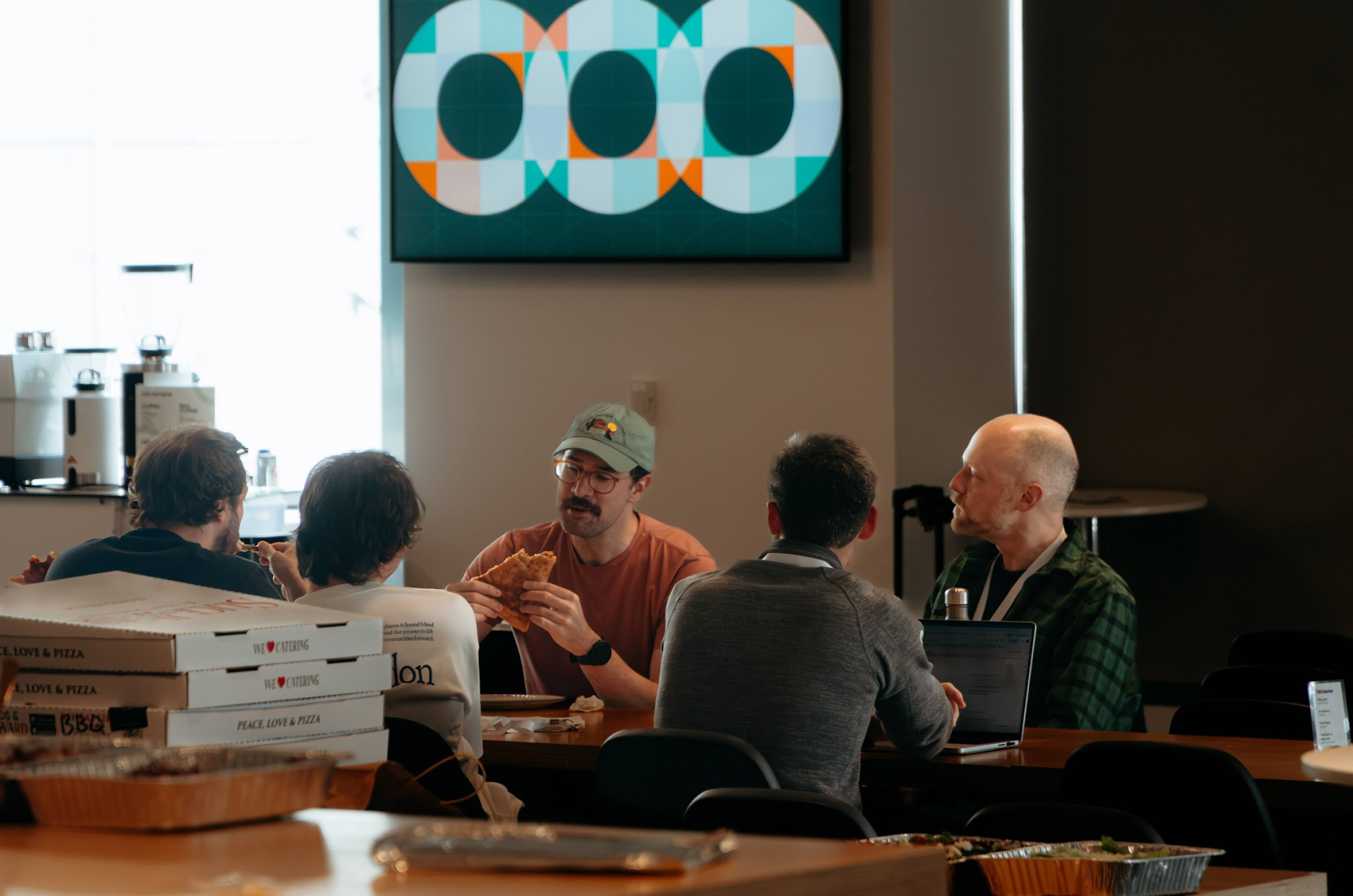 Semgrep Engineers discussing their Hackathon work over pizza.